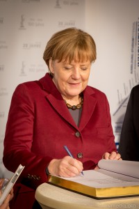 Angela Merkel trägt sich in das Goldene Buch des Stadt Leuna ein.