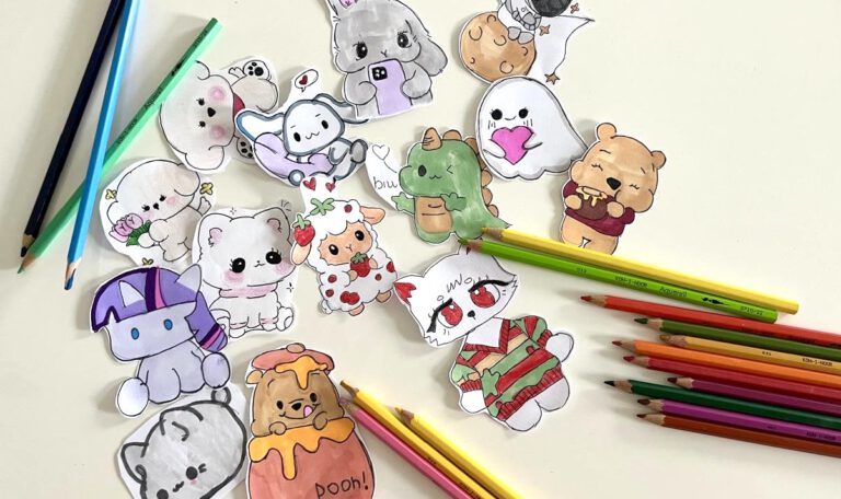 На картинке — лист бумаги с яркими детскими рисунками. Рядом разбросаны цветные карандаши, некоторые с затёртыми концами. Всё выглядит живо и по-доброму, передаёт атмосферу творчества и беззаботного детства.