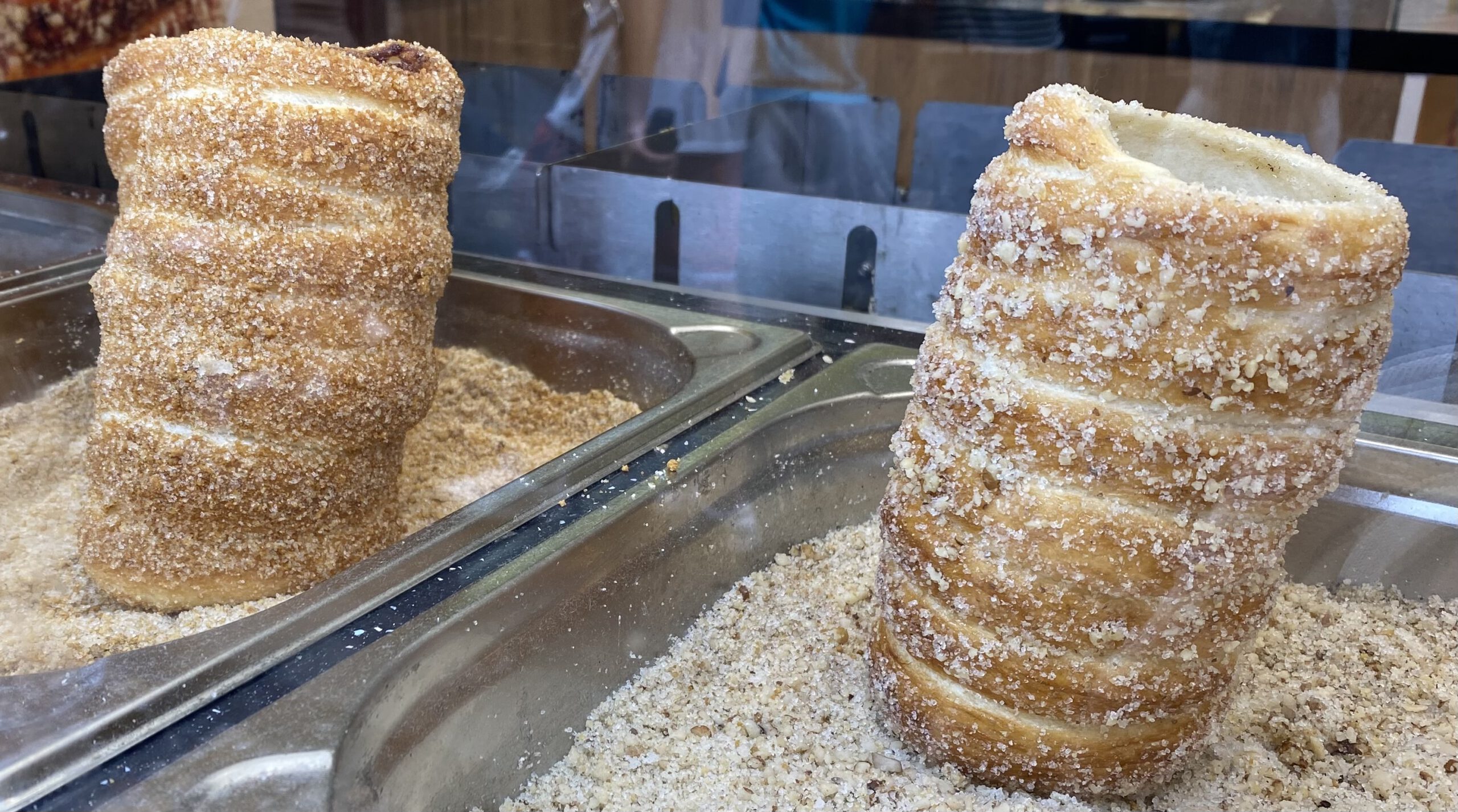 Витрина с традиционными чешскими трубочками Trdelník. Аппетитные булочки выложены в ряд, создавая яркую и вкусную композицию.