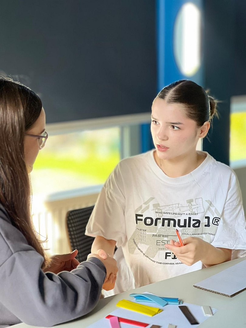 zwei Schülerinnen sitzen am Tisch und diskutieren über Diskriminierung in der Jugendherberge in Klingenthal