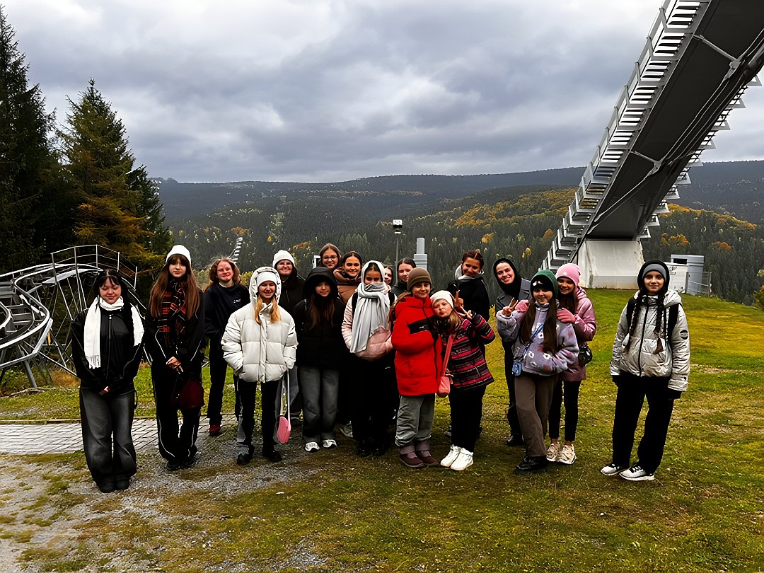 Kinder und Jugendliche, Kursleiterin un Betreuerinnen stehen vor der Skischanze in Klingenthal