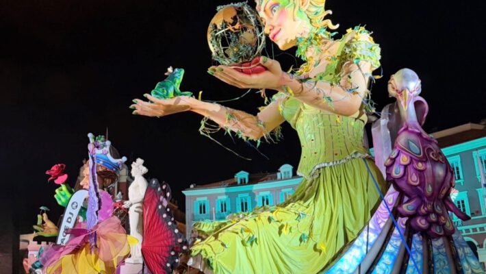 Огромная карнавальная фигура девушки возвышается над улицей, яркая и впечатляющая своими масштабами.