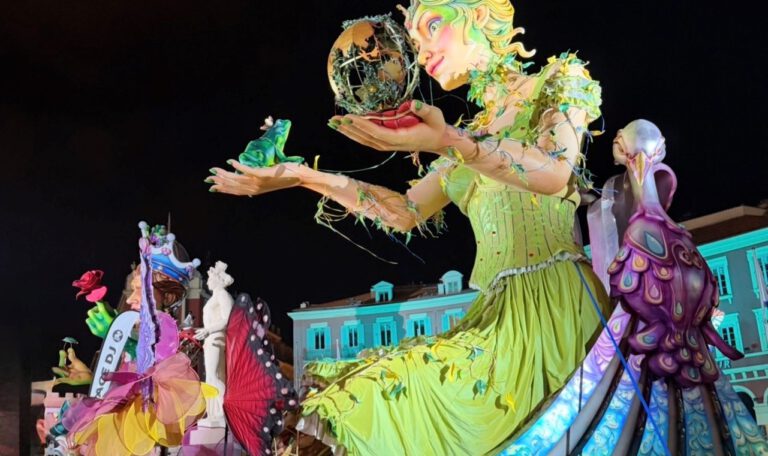 Огромная карнавальная фигура девушки возвышается над улицей, яркая и впечатляющая своими масштабами.