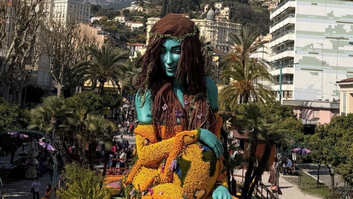 Большая фигура девушки, созданная из цитрусовых, возвышается над площадью и выглядит ярко и необычно.