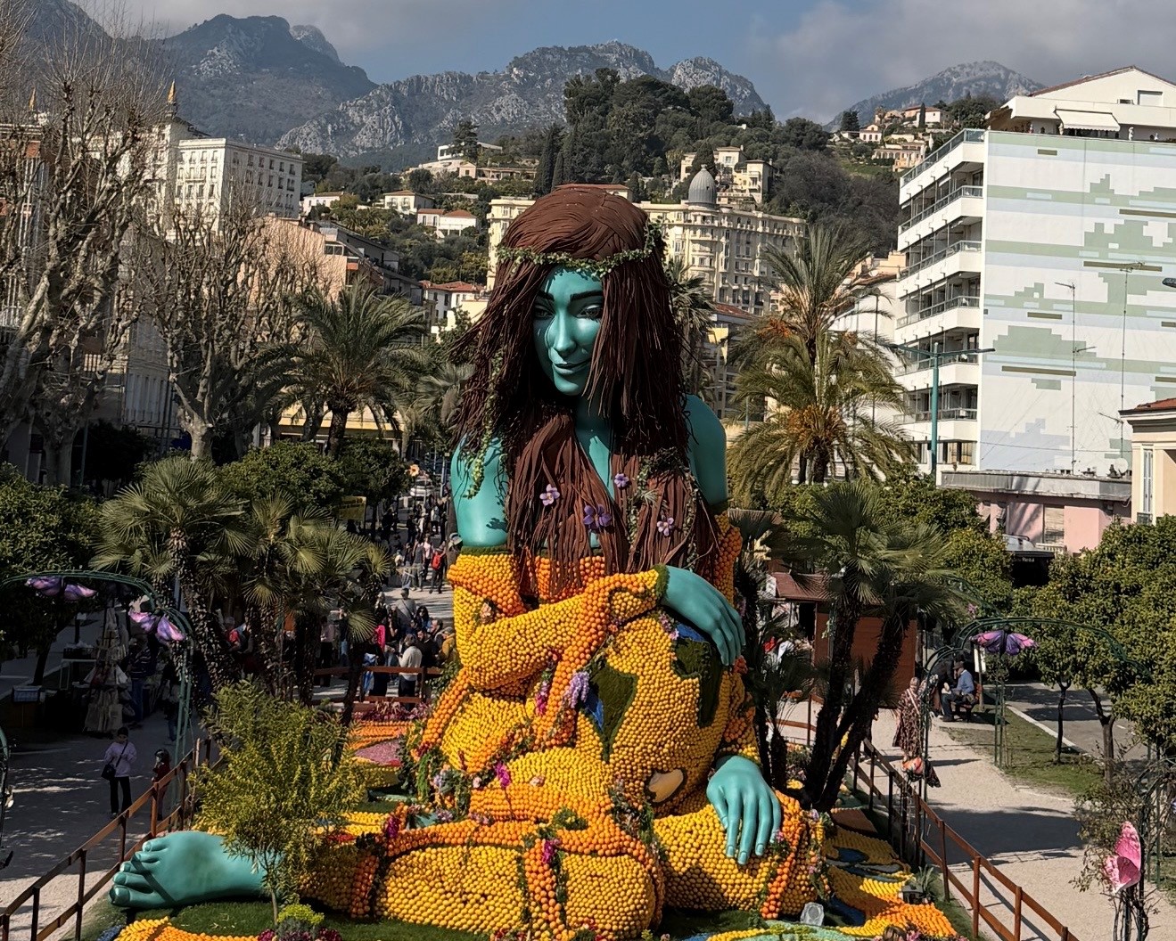Большая фигура девушки, созданная из цитрусовых, возвышается над площадью и выглядит ярко и необычно. Большая фигура девушки, созданная из цитрусовых, возвышается над площадью и выглядит ярко и необычно.