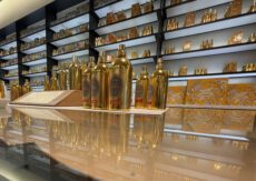 Полки с аккуратно расставленными флаконами духов разных форм и размеров.