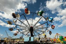 Карусель Leipziger Kleinmesse на фоне синего неба с облаками: весенняя ярмарка в Лейпциге, развлечения для всей семьи