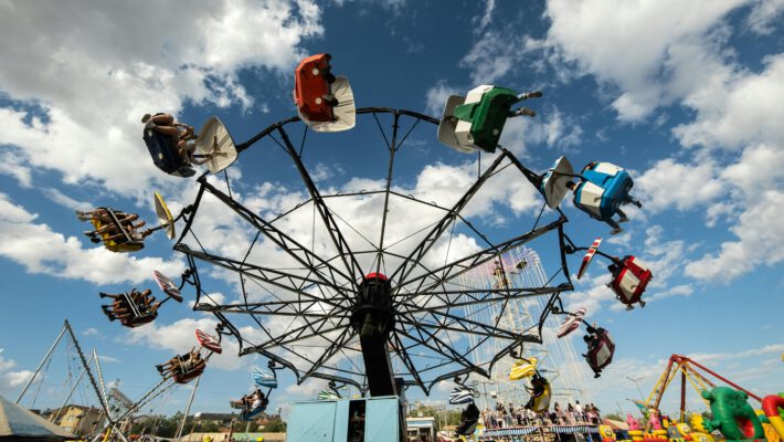 Карусель Leipziger Kleinmesse на фоне синего неба с облаками: весенняя ярмарка в Лейпциге, развлечения для всей семьи