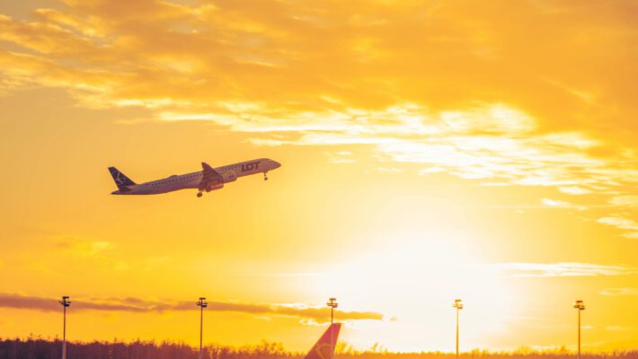 Самолет LOT Polish Airlines взлетает на фоне заката над стоящим лайнером Ryanair Ограничения на полеты затронули логистику в ключевых авиаузлах Европы