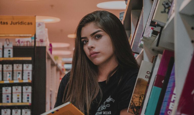 Молодая читательница на Книжной ярмарке в Лейпциге 2026 держит открытую книгу. Крупный план девушки на фоне книжных стеллажей на фестивале 'Leipzig liest'. Атмосфера интереса к чтению на Leipziger Buchmesse.