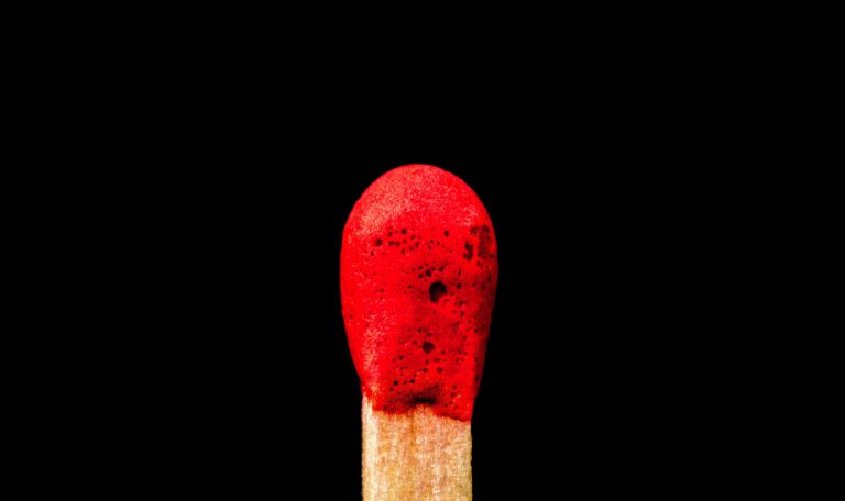 Макросъемка красной спички на черном фоне как символ начала войны с Ираном и эскалации на Ближнем Востоке