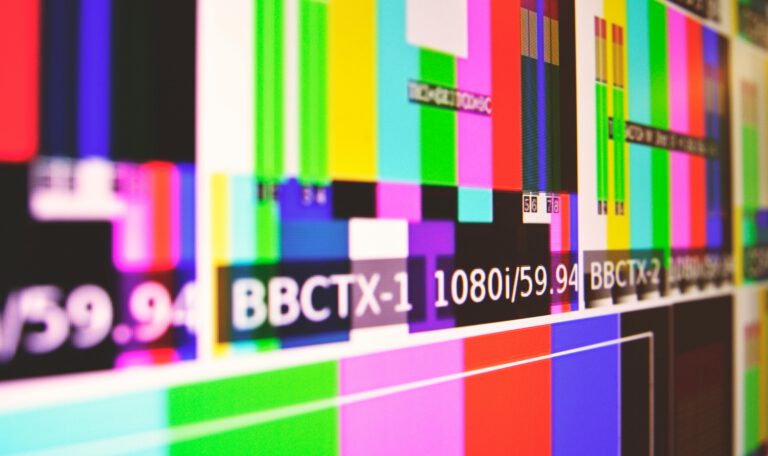 Телевизионная тестовая таблица с цветными полосами и технической информацией на экране монитора: Крупный план, символизирующий перебои в вещании и технические проблемы