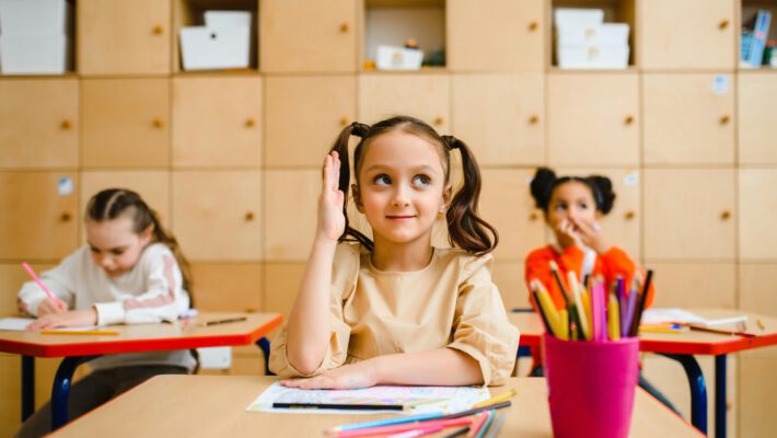 Символ утерянного доверия и нарушенных границ. На первый взгляд, это обычный школьный класс: девочка прилежно поднимает руку, готовая к ответу, вокруг разложены цветные карандаши, а на заднем плане видны уютные деревянные шкафчики. Это воплощение детской любознательности и доверия к учителю. В контексте громкого скандала в Саксонии, где на уроке «смелости» подросткам показали материалы категории «18+», это изображение приобретает зловещий оттенок. Поднятая рука ученицы становится символом открытости миру и беззащитности перед лицом того контента, который педагоги решили принести в класс. Фотография подчеркивает хрупкость детской психики и ту огромную ответственность, которая лежит на взрослых. Она задает немой вопрос: когда эти руки опускаются, что остается в их умах после «уроков», где стерты границы дозволенного? Это изображение служит напоминанием о том, что школа должна быть безопасным пространством для получения знаний, а не местом для шокирующих экспериментов.