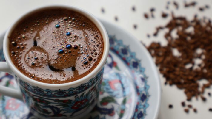 Чашка крепкого кофе робуста с пенкой на фоне рассыпанных зерен — иллюстрация к статье про глобальный рынок кофе 2026