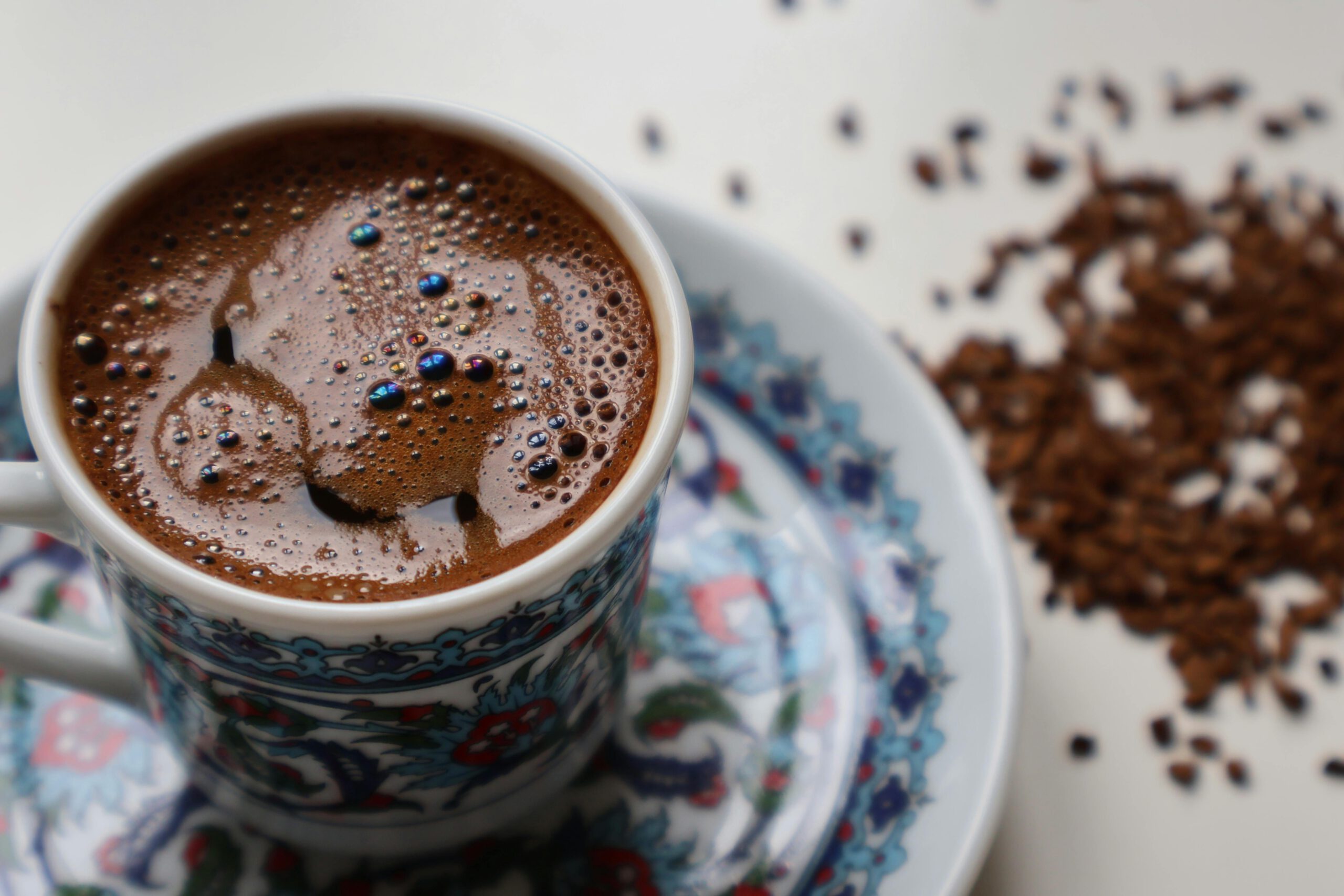 Чашка крепкого кофе робуста с пенкой на фоне рассыпанных зерен — иллюстрация к статье про глобальный рынок кофе 2026