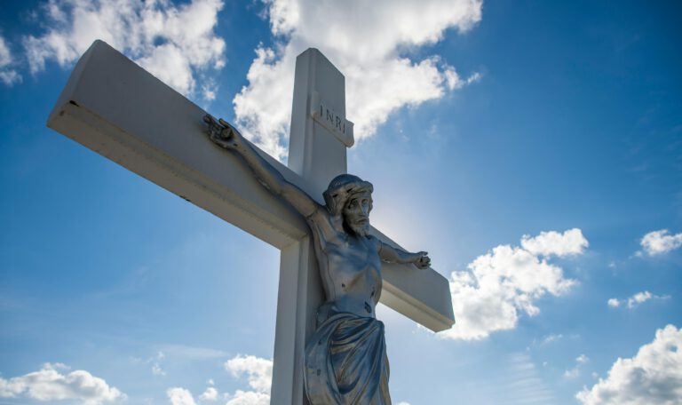 Распятие Иисуса Христа на фоне голубого неба с облаками — символ Страстной пятницы (Karfreitag) в Германии