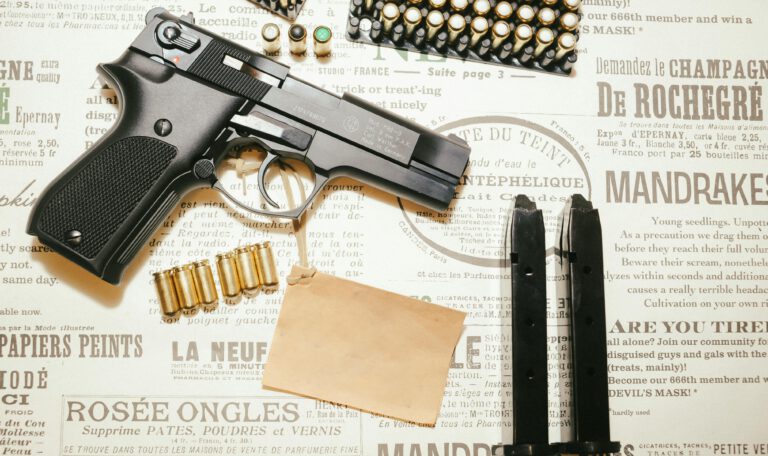 Детальное фото стартового (сигнального) пистолета Walther P88-9, 9 мм P.A.K., Made in Germany, на фоне винтажной французской газеты с патронами и магазинами.