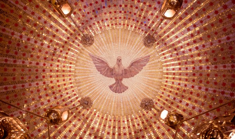 Потолок купола часовни, выложенный золотой и красной мозаикой, с центральным изображением голубя Святого Духа и четырьмя подвесными золотыми фонарями, вид снизу. Это изображение сопровождает статью о том, почему Трамп раскритиковал Мелони