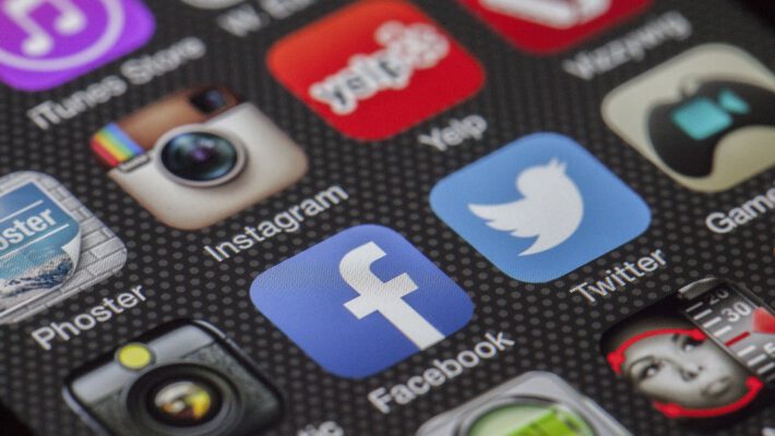 Крупный план экрана смартфона с иконками популярных социальных сетей и приложений, включая Facebook, Twitter, Instagram и Yelp.