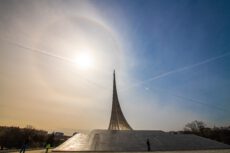 Німеччина вп'ятеро збільшує підтримку меморіалу «Яд Вашем». Величний титановий монумент у формі шлейфу від ракети, що стрімко злітає вгору, розташований на широкому кам'яному постаменті. На світлому небі яскраво світить сонце, утворюючи навколо себе кругове гало. Небо перетинають тонкі білі інверсійні сліди від літаків. На передньому плані видно силуети кількох людей, які гуляють площею біля пам'ятника.