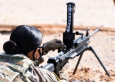 Військовослужбовиця у камуфляжній формі та захисних окулярах готує до стрільби великокаліберний кулемет на сошках на відкритому полігоні. Мобілізація жінок. Військовослужбовиця у камуфляжній формі та захисних окулярах готує до стрільби великокаліберний кулемет на сошках на відкритому полігоні. Мобілізація жінок.